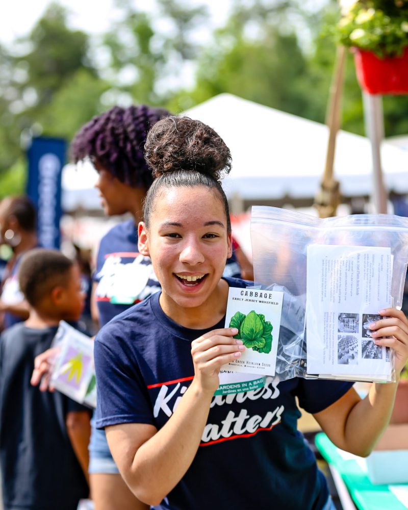 girl holding pamphlets at an event